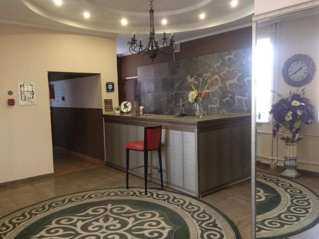 a kitchen with a bar and a red stool at Altyn Adam Hotel in Pavlodar