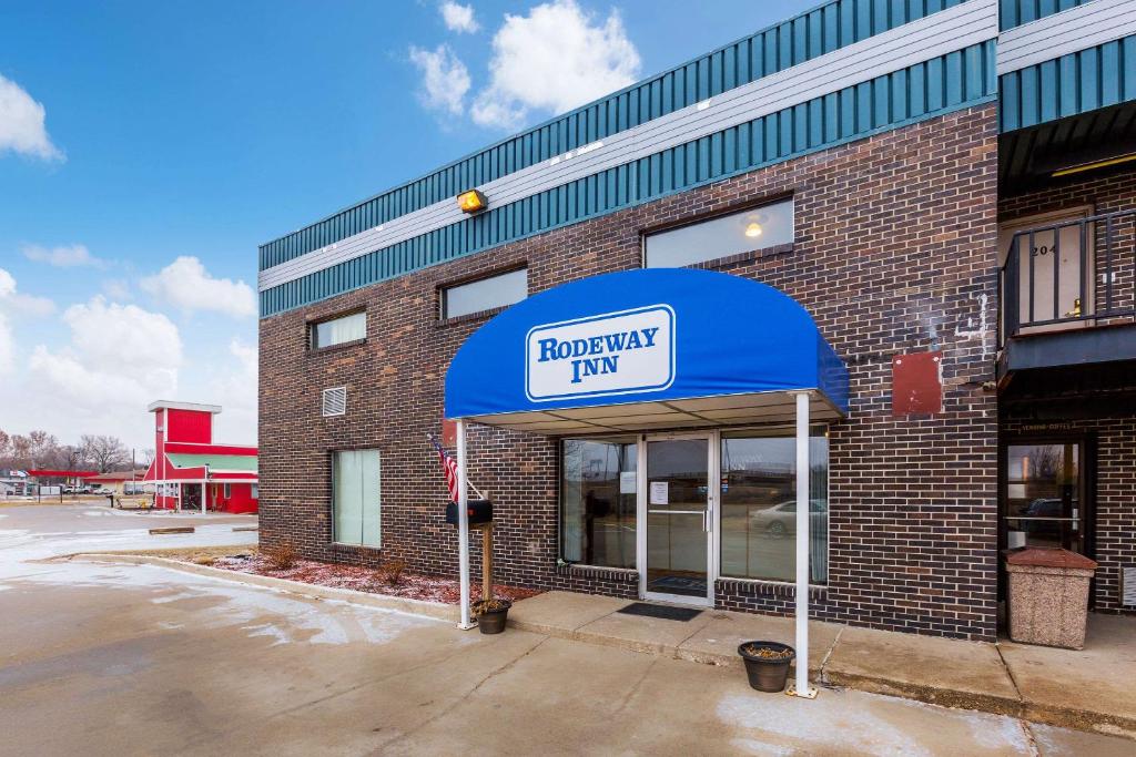 a brick building with a blue awning on it at Rodeway Inn Sergeant Bluff - Sioux City in Sergeant Bluff