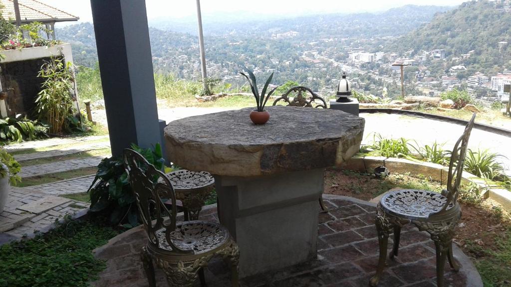 a stone table and chairs with a view of a city at Lawan One Kandy in Kandy