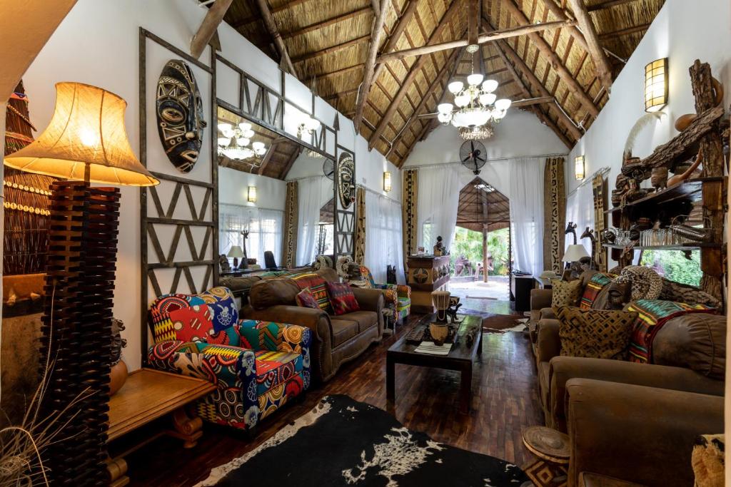 een woonkamer met meubilair en een kroonluchter bij Ngoma Zanga Lodge in Livingstone