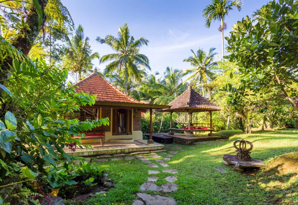 une petite maison avec un kiosque dans un jardin dans l'établissement Prana Dewi Mountain Resort, à Jatiluwih