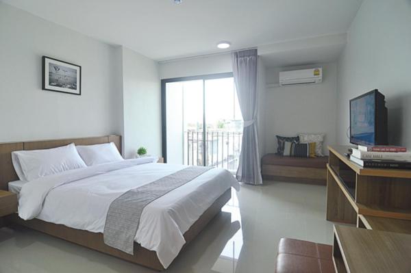 ein Schlafzimmer mit einem großen Bett und einem TV in der Unterkunft 24Residence Siriraj in Bangkok