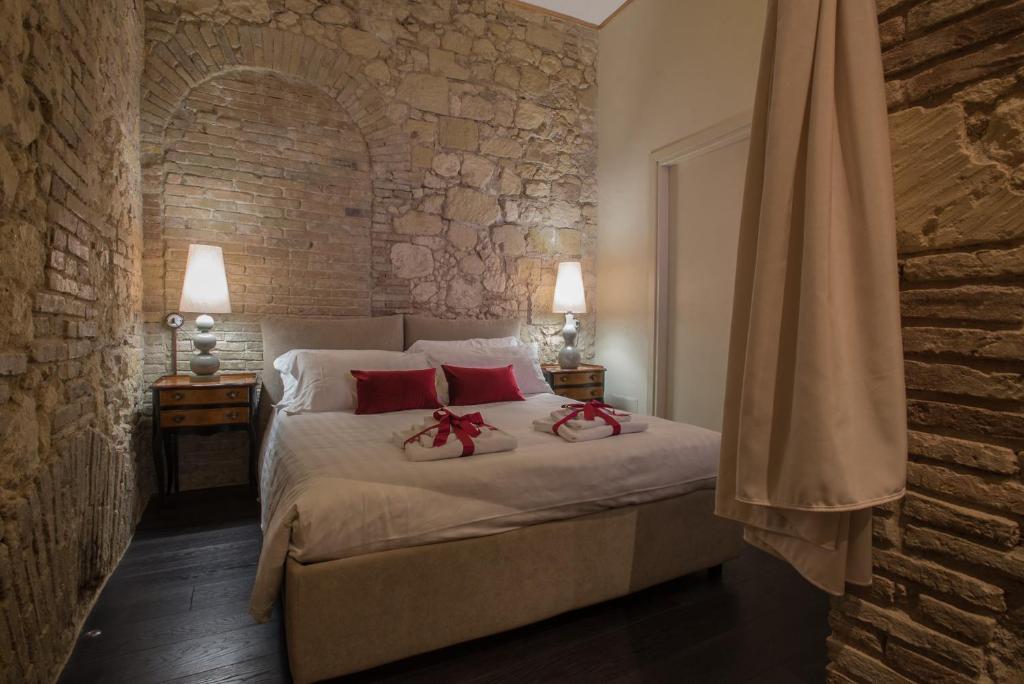 a bedroom with a bed with two red pillows on it at Suite via Sulis 61 in Cagliari