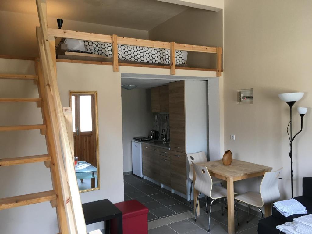 Habitación con cama elevada, mesa y cocina. en Joges Apartment en Krinídhes
