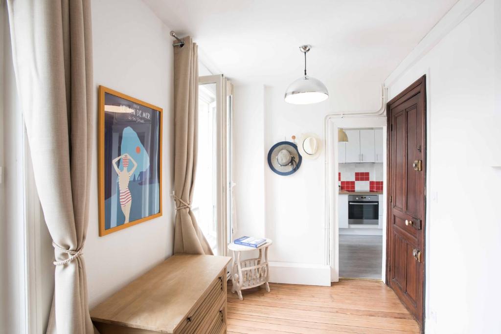 a living room with a wooden table and a hallway at Tout à pied - Appartement - parking privé - 80m des falaises - Plein centre in Étretat