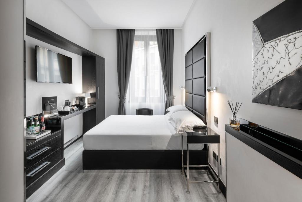 a hotel room with a bed and a television at LHP Hotel Napoleon in Milan