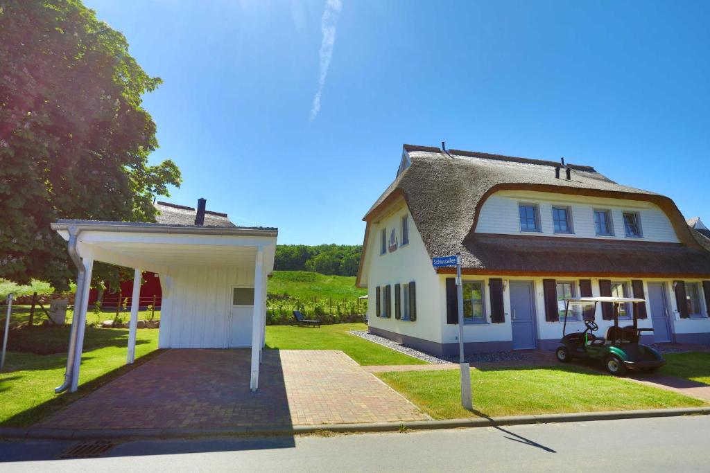 a large white house with a garage in front of it at Neu Reet Ferienhaus Svantevit in Lohme