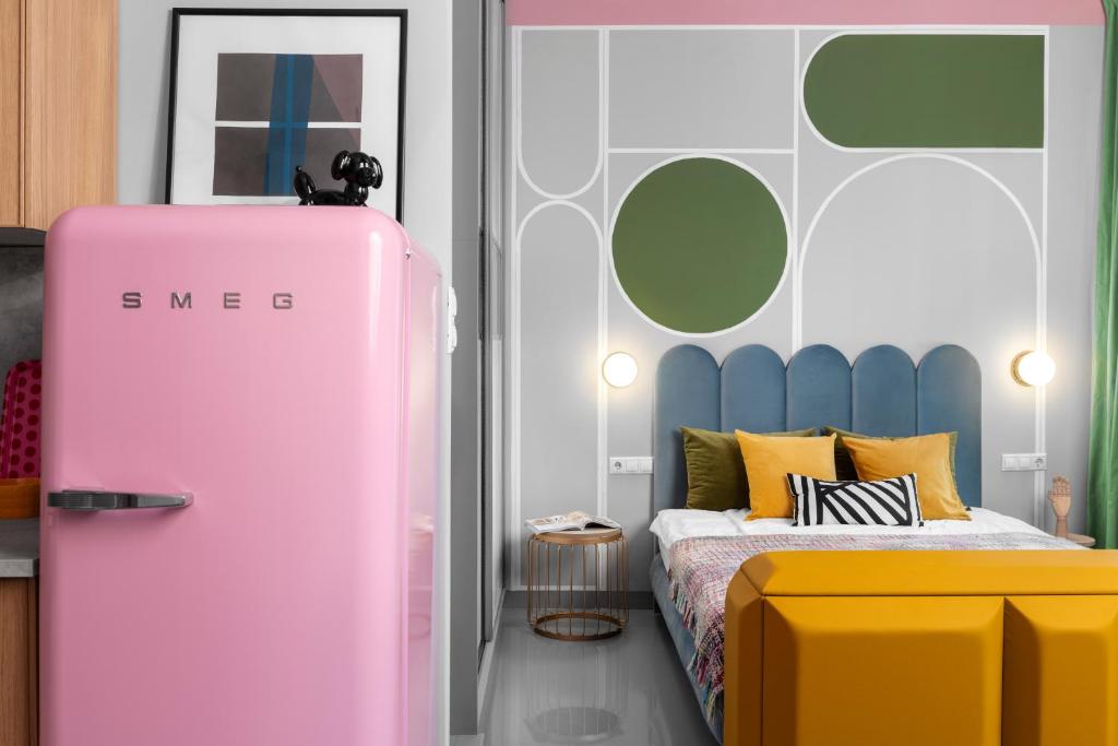 a bedroom with a pink refrigerator next to a bed at Lucifer Apartment in Budapest
