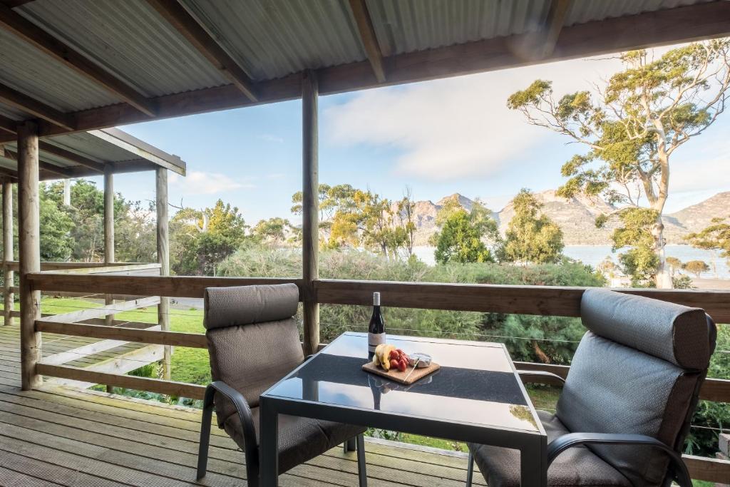 a table and two chairs on a deck with a view at Freycinet Cottage 2 – Dolerite in Coles Bay