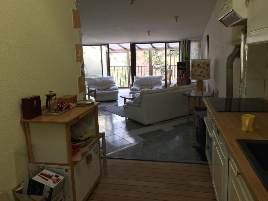 eine Küche und ein Wohnzimmer mit einem Sofa und einem Tisch in der Unterkunft le grenier d'Annick in Villefort
