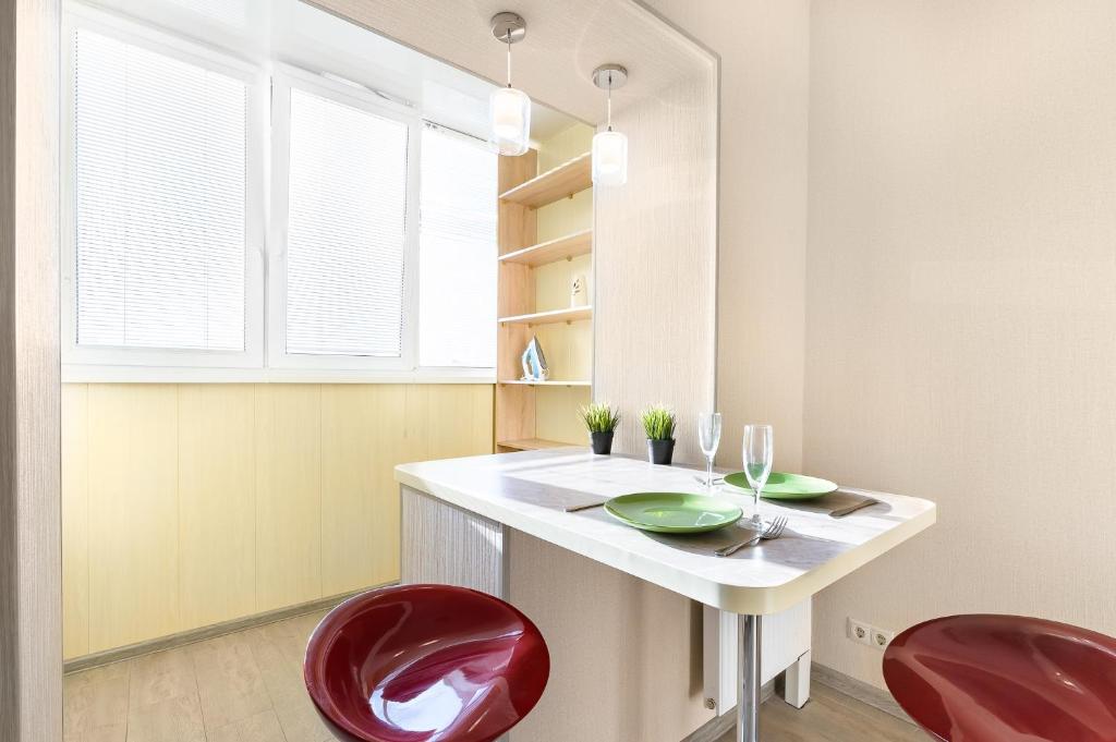 ムイティシにあるВаша Зона Комфорта на Колпакова 29のキッチン(赤い椅子2脚、白いカウンター付)