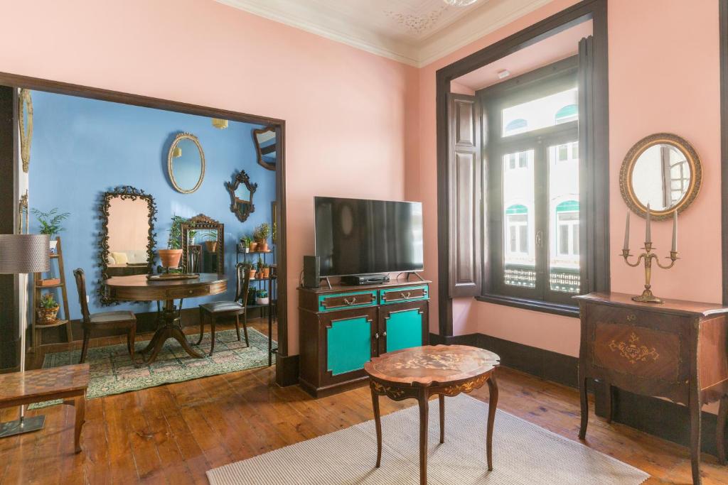 uma sala de estar com uma televisão e uma mesa em Charming Guest House in a 19th Century Building em Lisboa