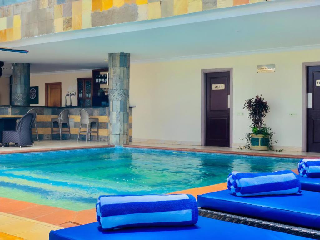 a large swimming pool with blue pads in a building at CBD Hotel in Dar es Salaam