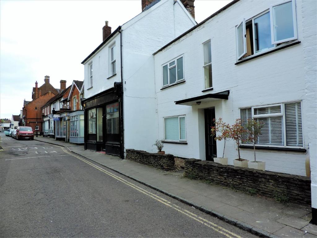 une rue avec des bâtiments blancs dans une rue de la ville dans l'établissement 1 Bed Bagshot Pennyhill Accommodation, à Bagshot