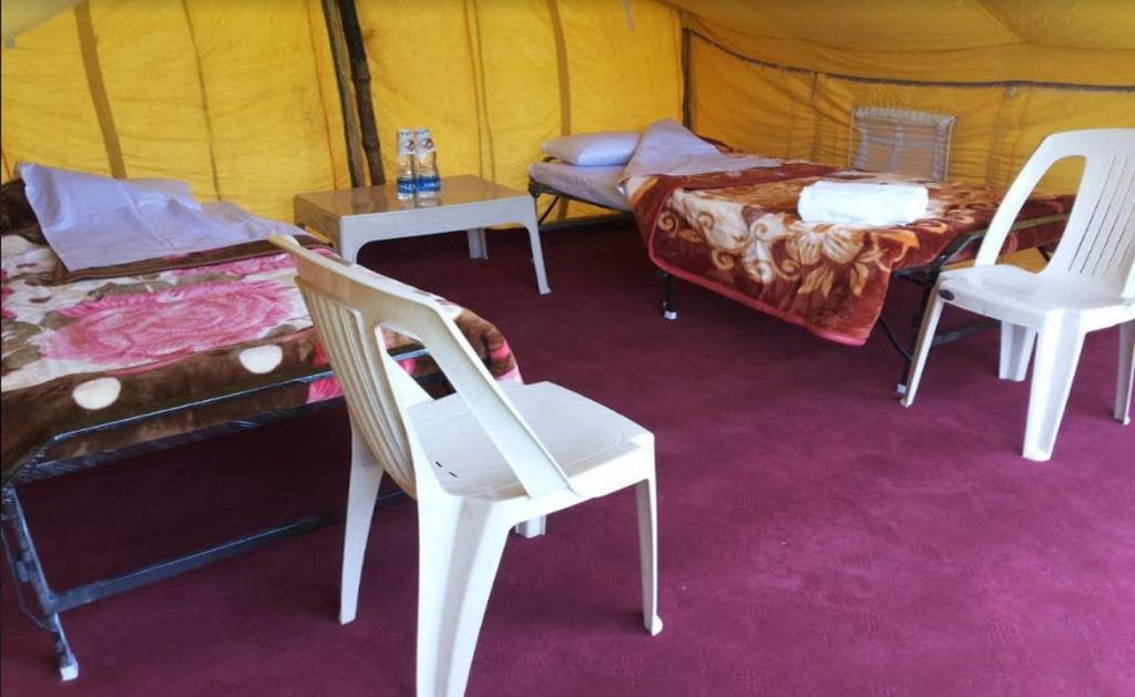 a room with chairs and a bed and a tent at Aru Camping Resort Aru, J&K in Pahalgām