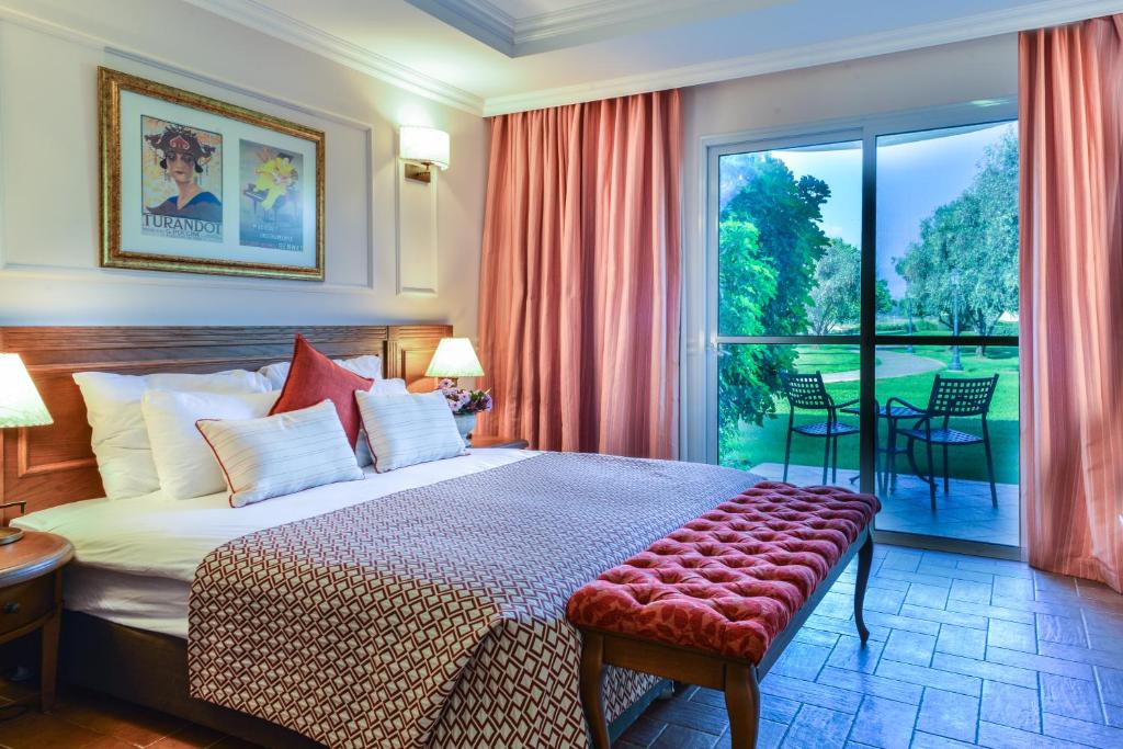 a hotel room with a bed and a large window at Pastoral Hotel - Kfar Blum in Kfar Blum