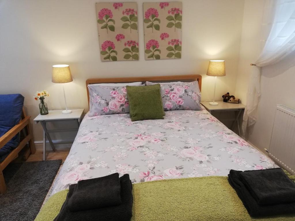 a bedroom with a large bed with two night stands at Rosehips at Kerensa, Naburn in York