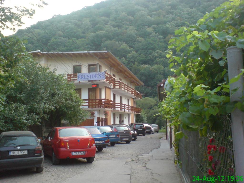 a row of cars parked in front of a building at Pension President in Băile Herculane