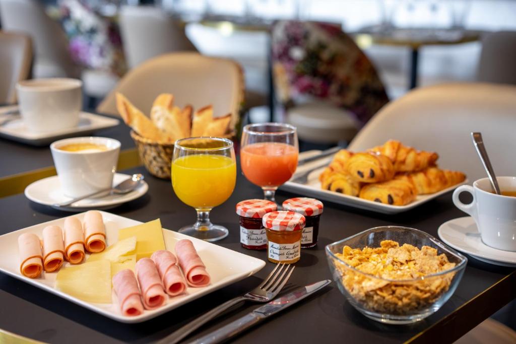 a table topped with plates of food and drinks at Hôtel Royal Opéra in Paris