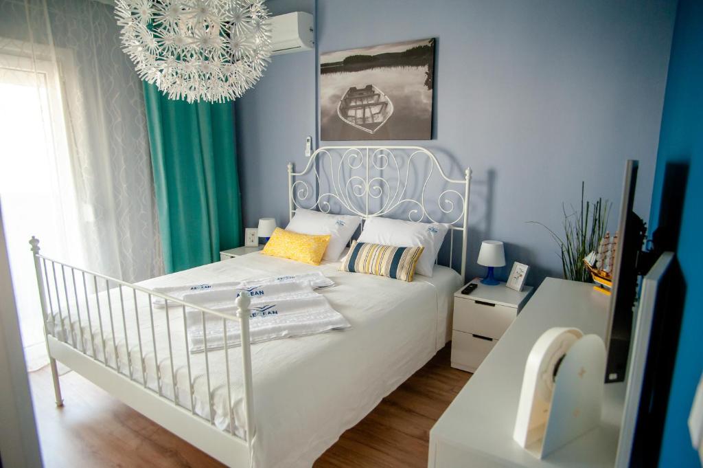 a bedroom with a white bed and a chandelier at Aegean Family Apartment in Perea