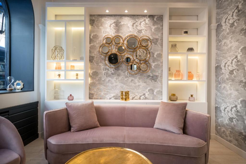 a living room with a couch and a wall with plates at Hôtel Royal Opéra in Paris