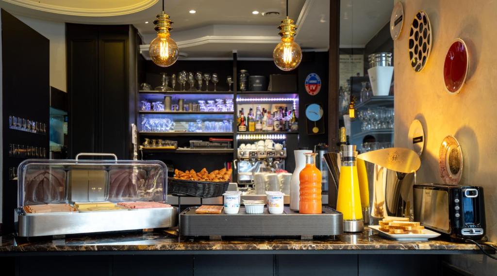 a bar with a counter with food and drinks at Hôtel Royal Opéra in Paris