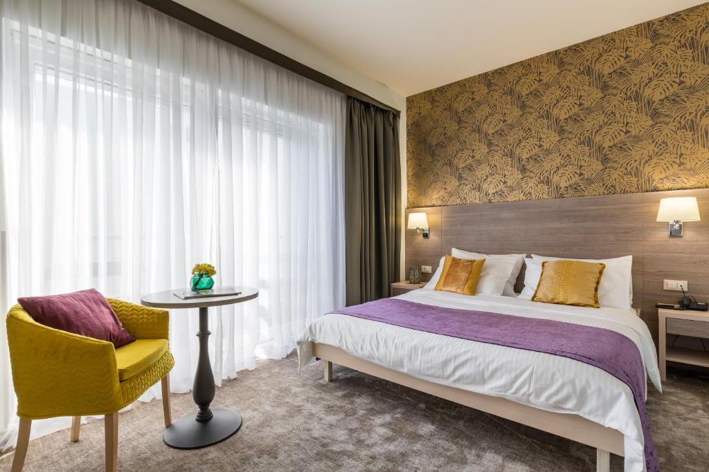Hotel Mondo في سبليت: غرفة نوم بسرير وطاولة وكرسي