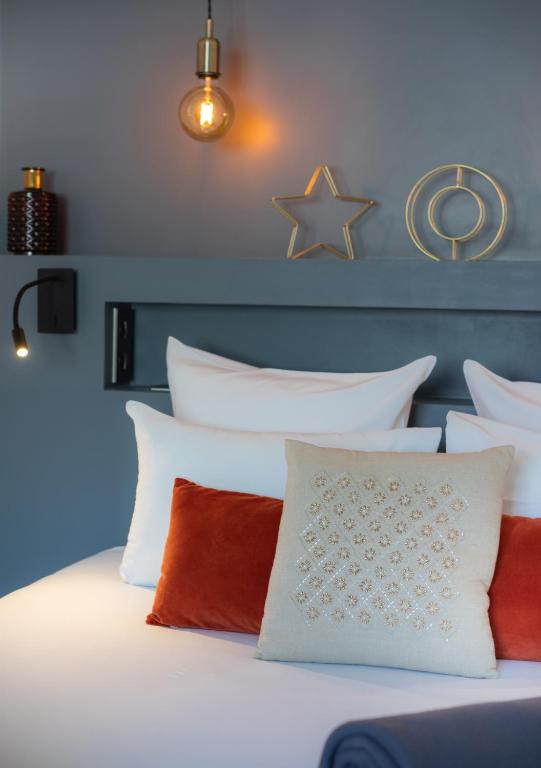 a bedroom with a white bed with red and white pillows at Hôtel Royal Opéra in Paris