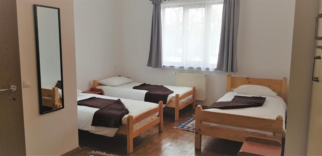 a small room with two beds and a mirror at Coroian House in Cluj-Napoca