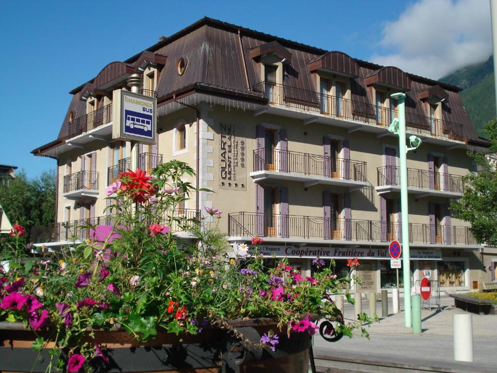 un grand bâtiment avec des fleurs devant lui dans l'établissement Quartz-Montblanc, à Chamonix-Mont-Blanc