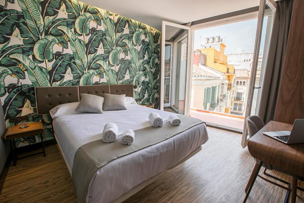 
a bedroom with a large bed and a large window at Málaga Premium Hotel in Málaga
