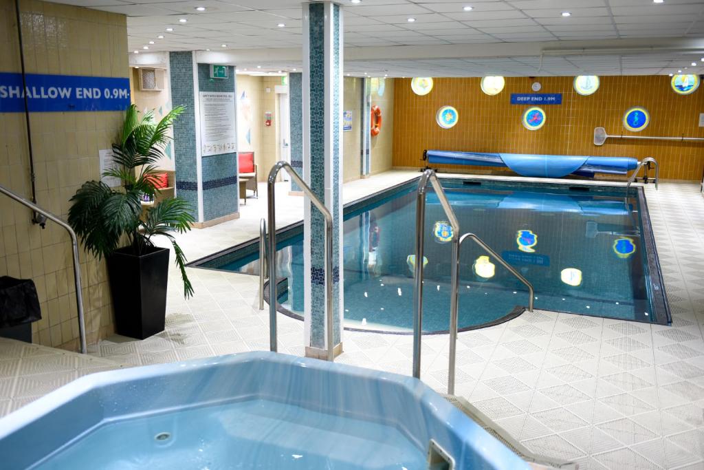 a swimming pool in a building with a tub at The Riviera Hotel & Holiday Apartments Alum Chine in Bournemouth