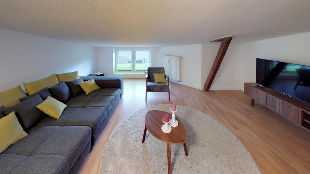a living room with a couch and a television at Altes Warmbad Wolgast in Wolgast