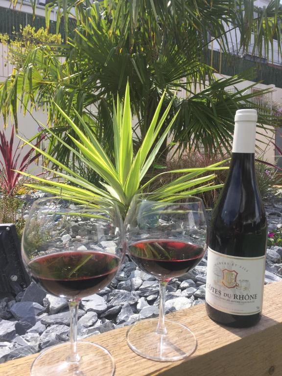 two glasses of red wine next to a bottle of wine at The Riviera Hotel & Apartments - Alum Chine in Bournemouth