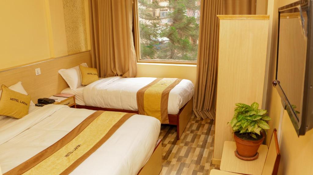 Habitación de hotel con 2 camas y ventana en Hotel Lapha, en Katmandú