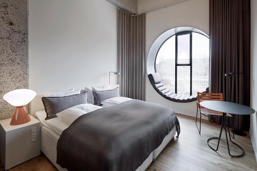 a bedroom with a large bed and a round window at Hotel Ottilia by Brøchner Hotels in Copenhagen