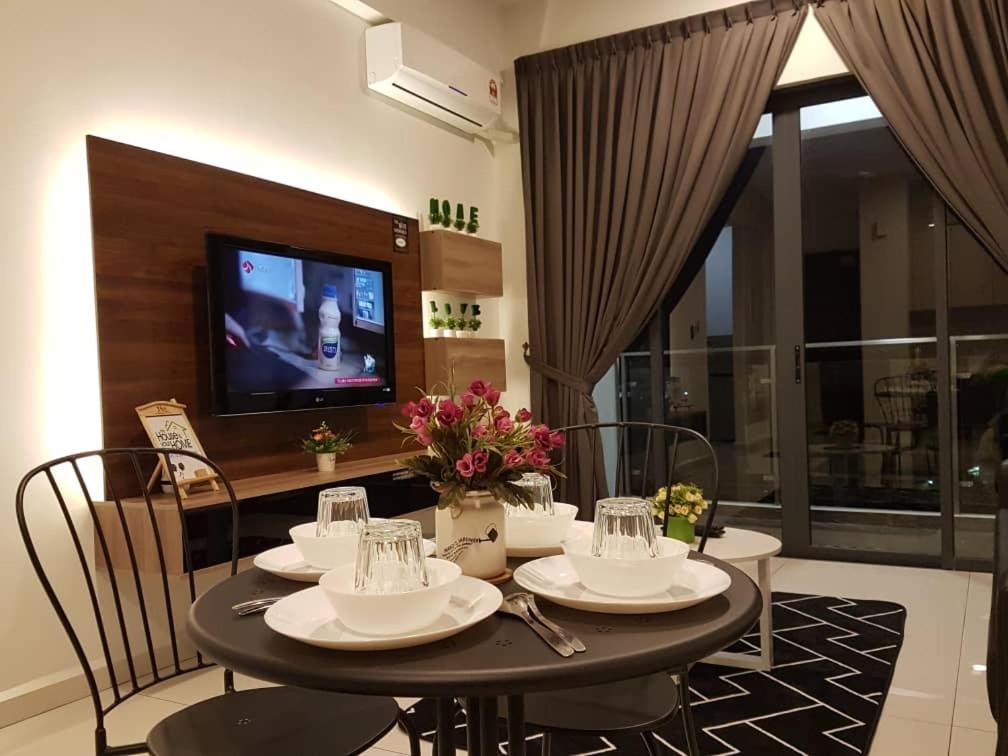 a dining room with a table with chairs and a television at Country garden danga bay ,bay point in Johor Bahru