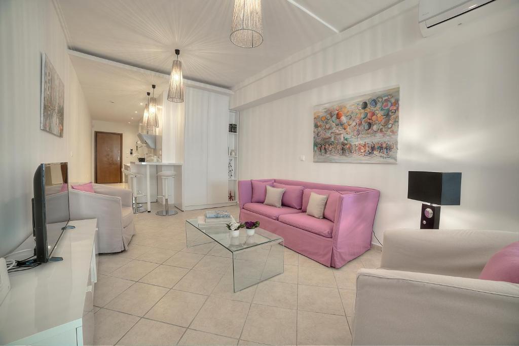- un salon avec un canapé rose et une télévision dans l'établissement Downtown Glyfada smart apartment, à Athènes
