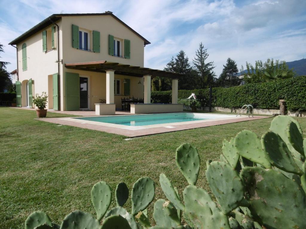 a villa with a swimming pool in front of a house at Casa Laura Capannori in Capannori