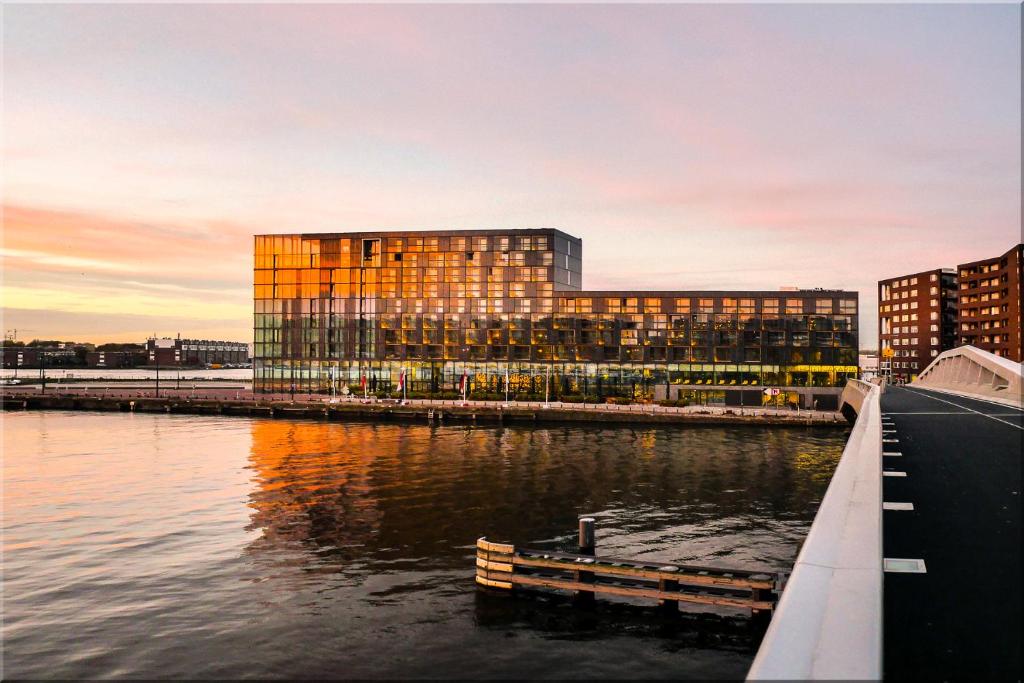 ein Gebäude neben einem Wasserkörper in der Unterkunft Hotel Jakarta Amsterdam in Amsterdam