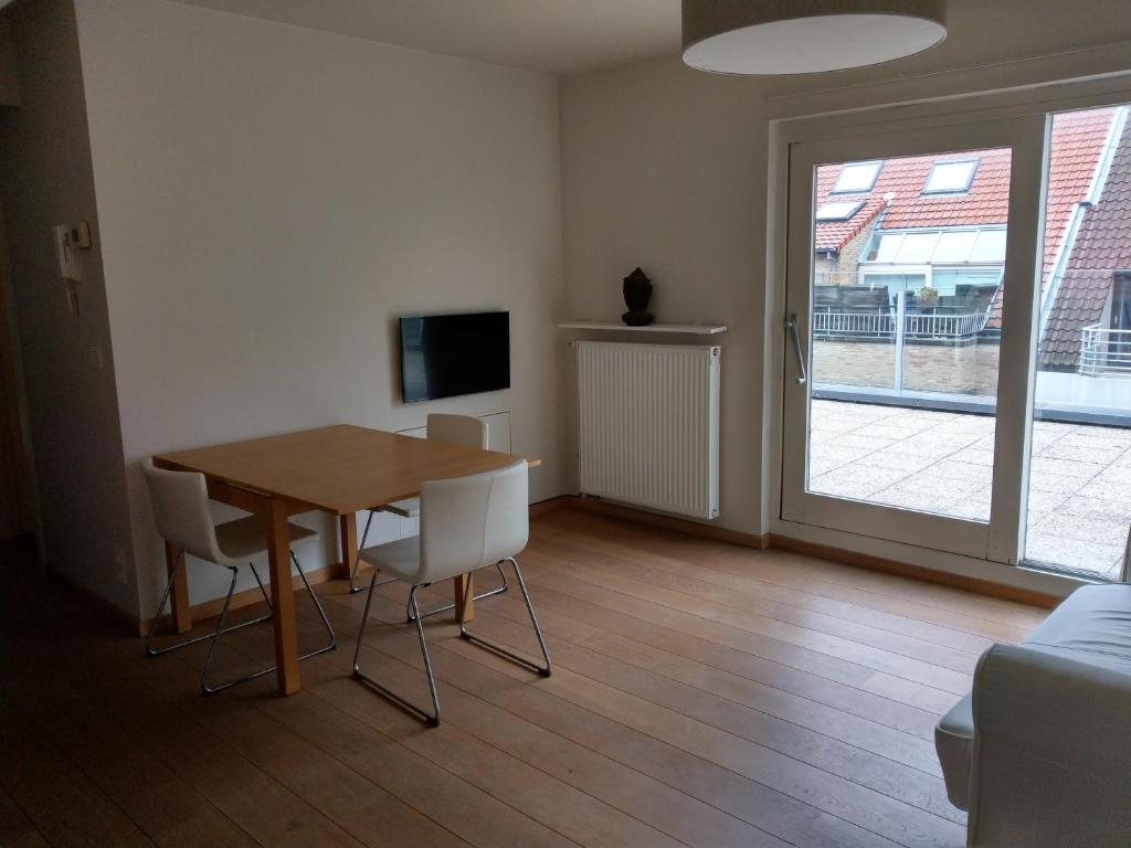 a dining room with a table and chairs and a television at Rooftop apartment with terras - top location in Knokke-Heist