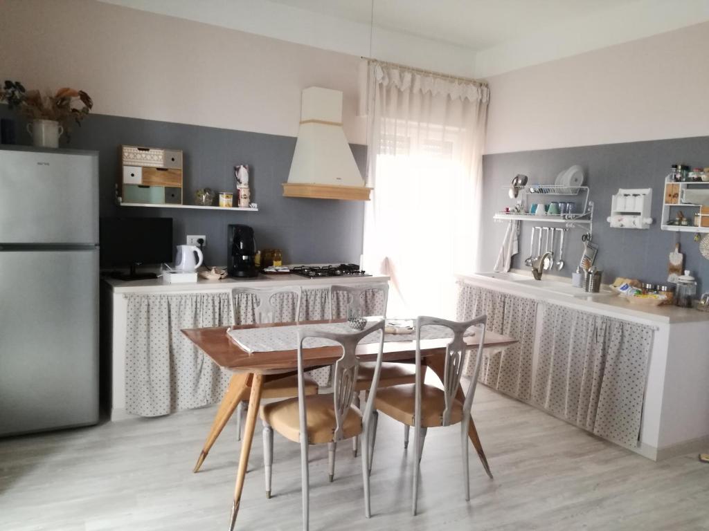 マテーラにあるCasa Vacanze Cappuccini 14のキッチン(テーブル、椅子、冷蔵庫付)