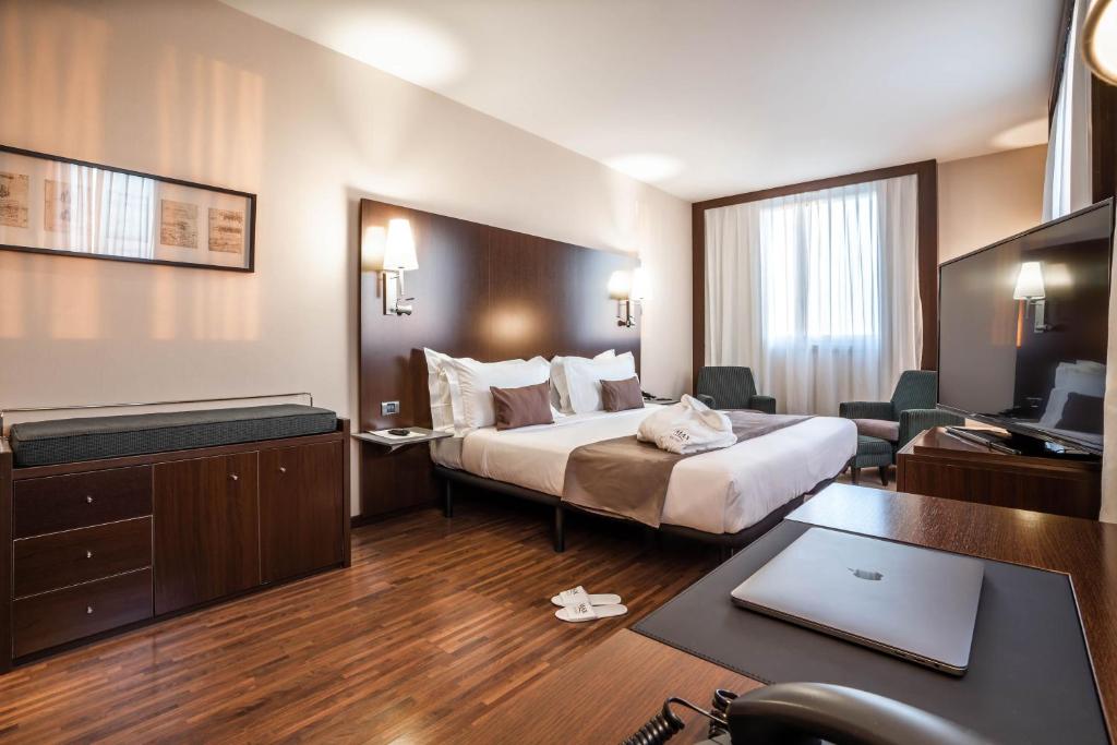 a hotel room with a bed and a desk at Max Hotel Livorno in Livorno