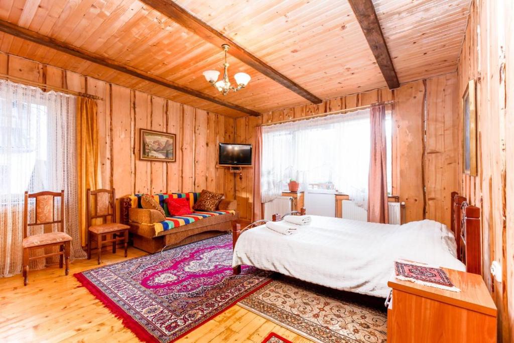 ヤレムチャにあるGutsulska Oselyaのベッドルーム(ベッド1台、ソファ付)