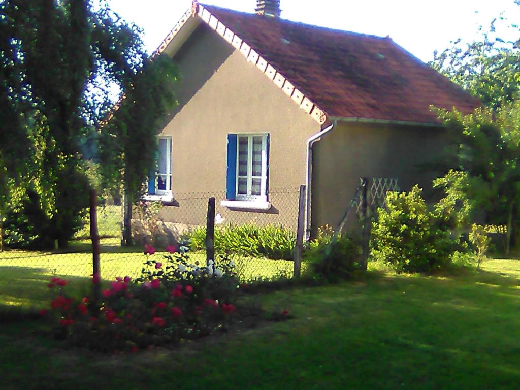 uma pequena casa com flores no quintal em Gîte La Maison de LEA em Saint-Agnant-de-Versillat