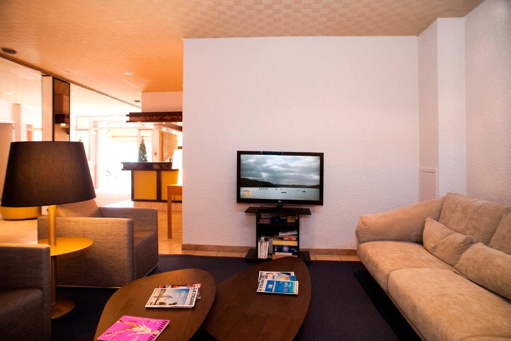 TV a/nebo společenská místnost v ubytování Hôtel Beau Rivage