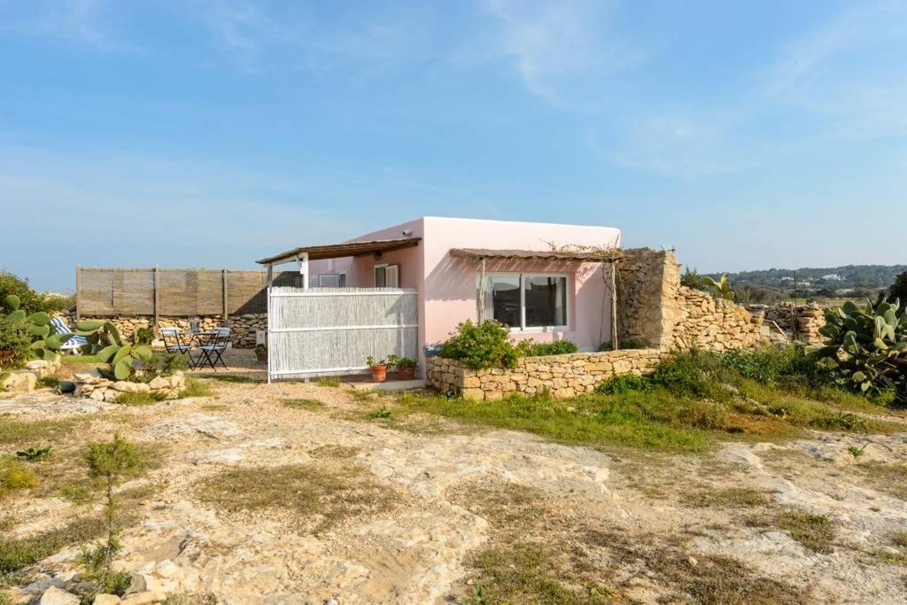 a small pink house on top of a hill at Sa Caseta La Casita in La Savina
