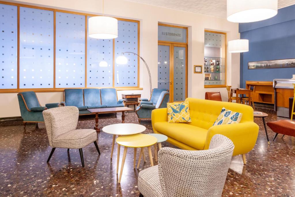 a lobby with couches and chairs and tables at ibis styles Trani in Trani