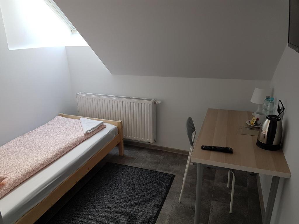 a small bedroom with a bed and a table at Noclegi u Andrzeja in Gdańsk