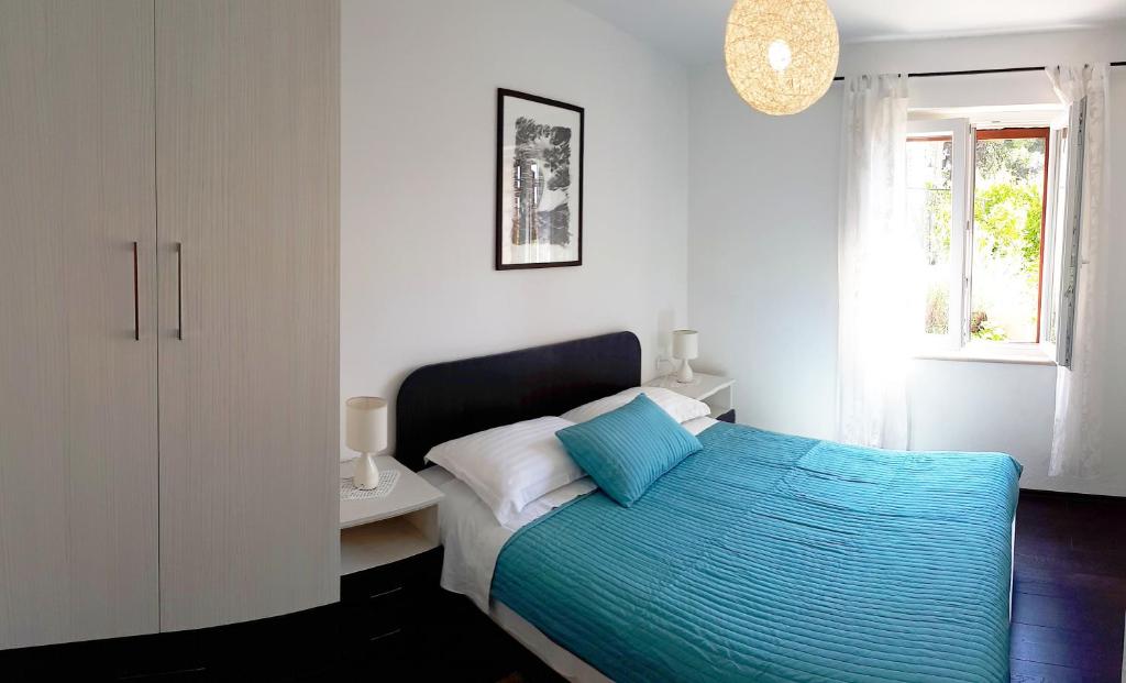 Accommodation Stella Mare في بول: غرفة نوم بسرير وملاءات زرقاء ونافذة